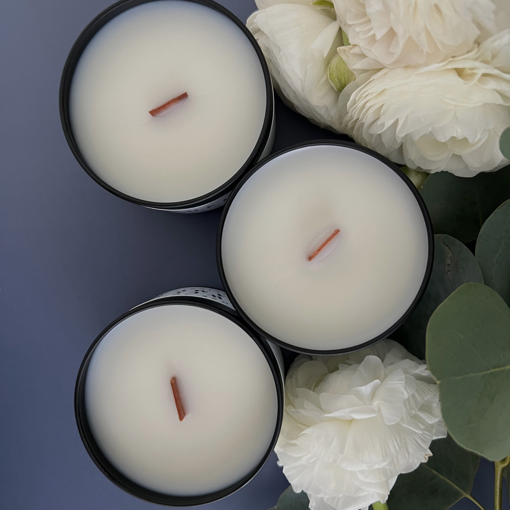 Aerial view of inside three Buko pandan candle surrounded by ranuncula flowers and eucalyptus