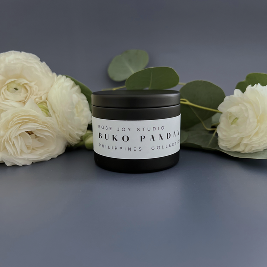 Buko pandan candle surrounded by peony flowers and eucalyptus